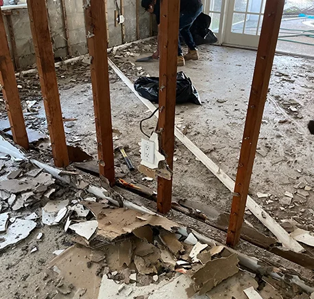 Blue flyer lists restoration services, quick response to health safety, with damaged room image.